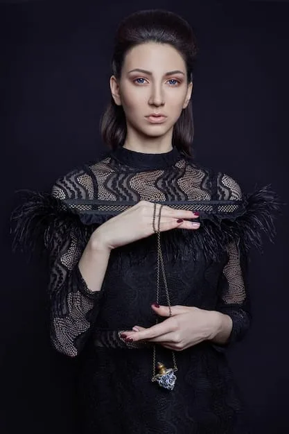 A close-up shot of a woman's formal black-tie attire, including a floor-length gown, elegant jewelry, and perfectly styled hair. The focus is on the details of the outfit and the overall impression of sophistication.