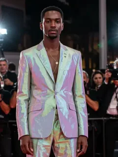 Avant-garde gender-fluid suit with digital elements on red carpet, 2026